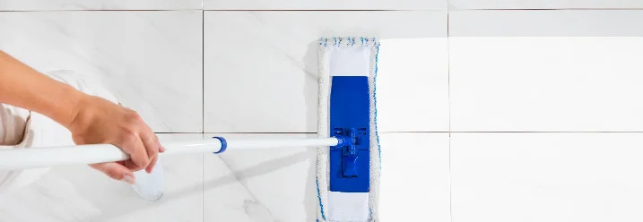 Person wischt Fliesen mit Wischmopp